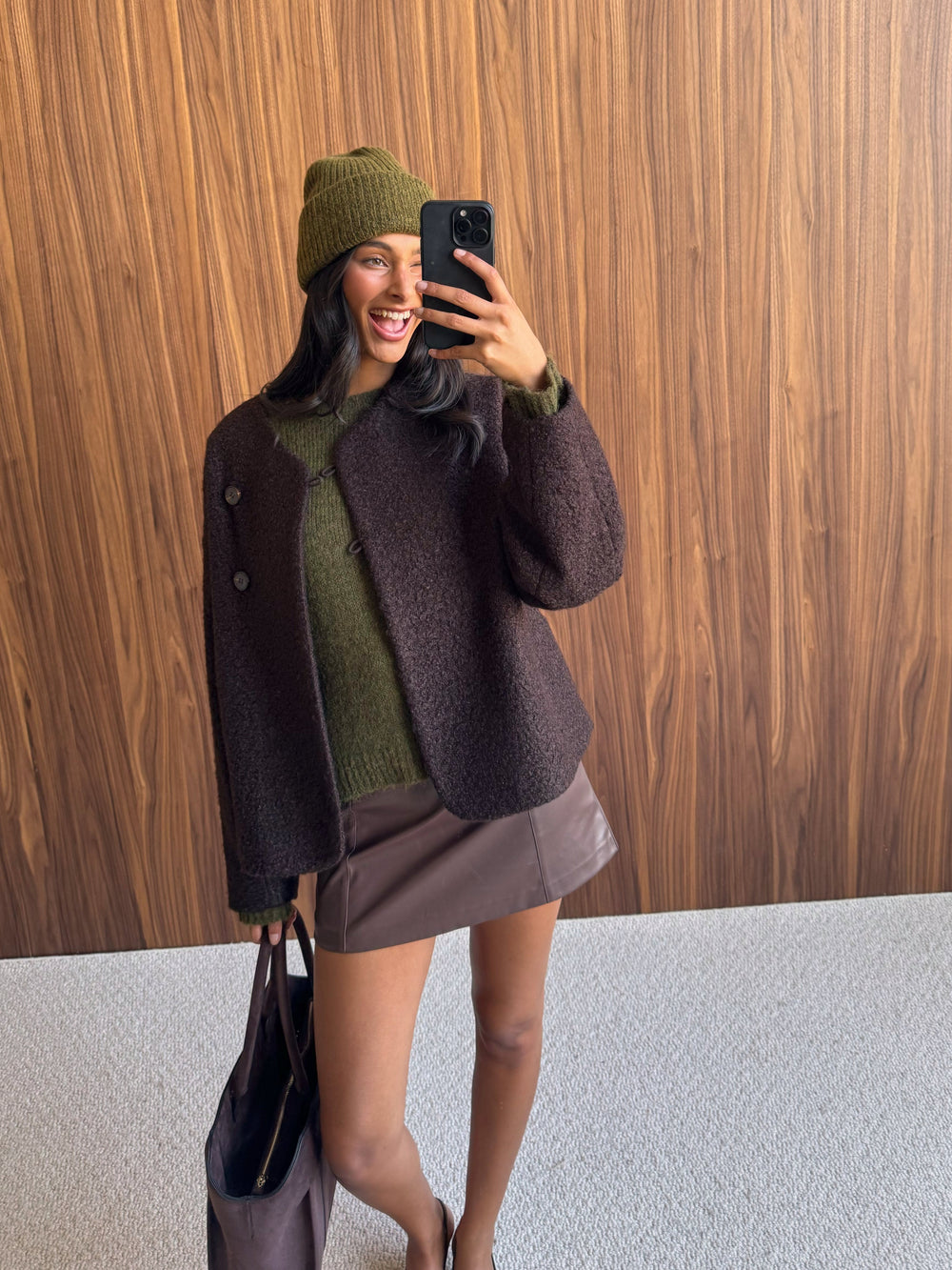 Olive green beanie, olive green sweater and brown jacket in a casual mirror selfie.